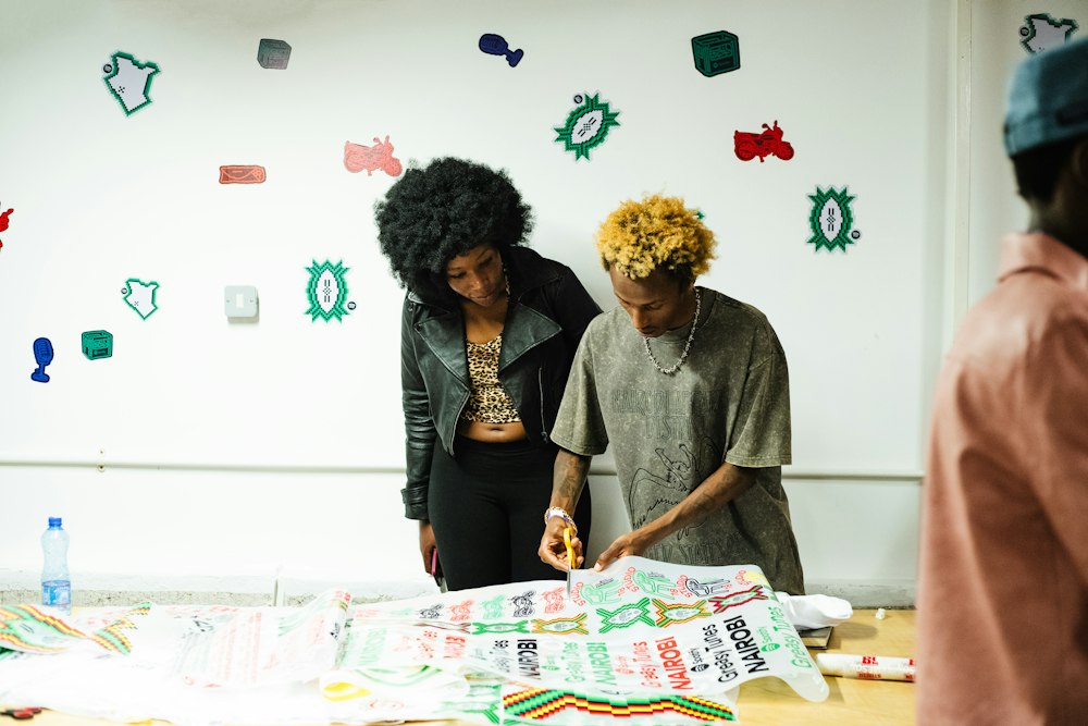 Two creatives at a wall of prints